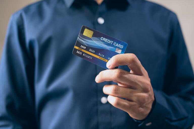 Persona sosteniendo una tarjeta de crédito con la mano